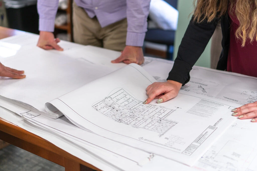 BCV team pointing at architectural plans