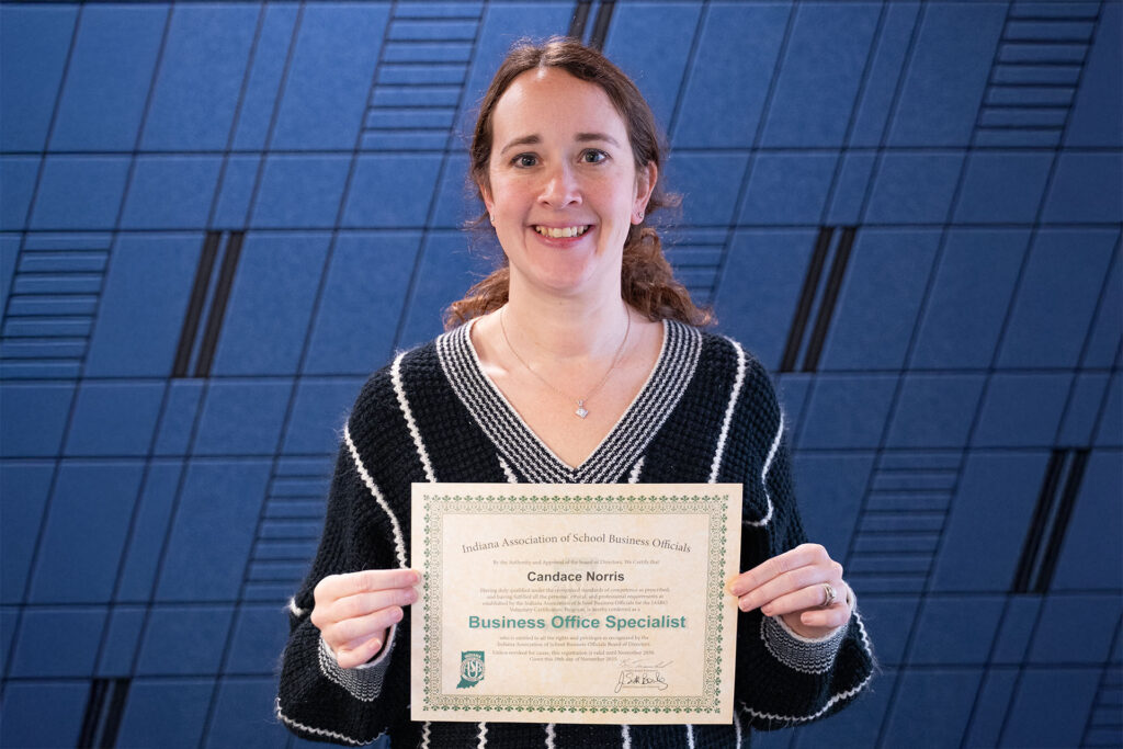 Candace Norris Holding her Business Office Specialist certificate from IASBO