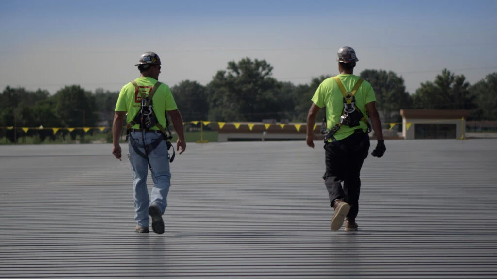 two men walking away from camera on construction site