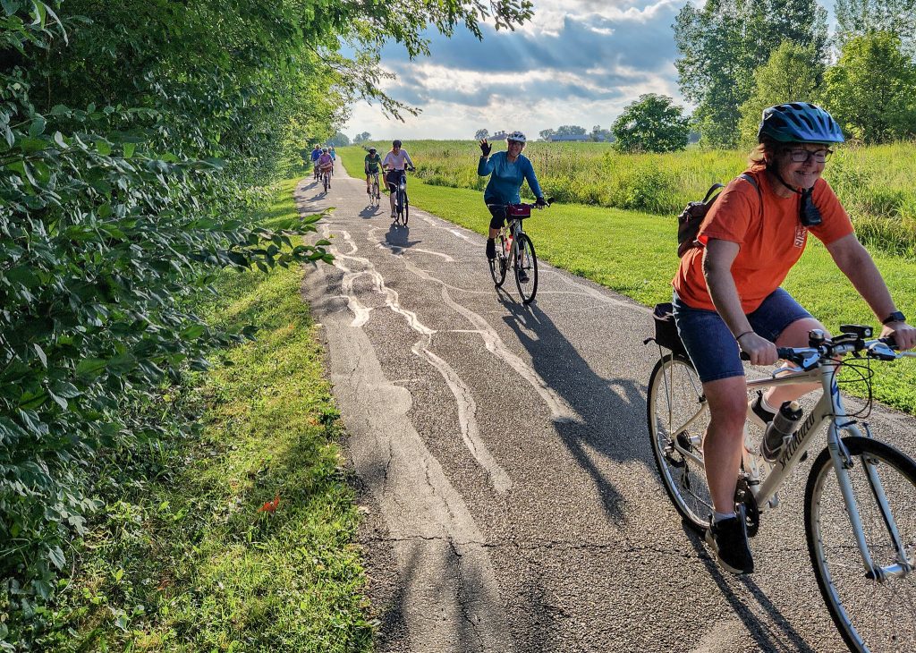 A group of bike riders on the Salomon Farm Park Loop. One rider is waving to the camera.
