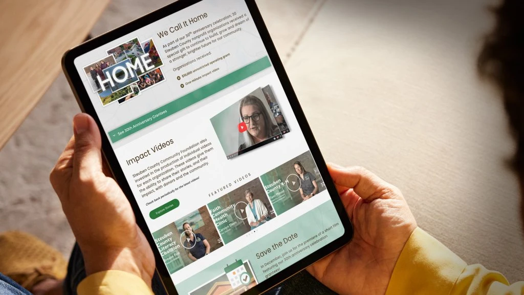 person holding tablet displaying Steuben County Community Foundation website