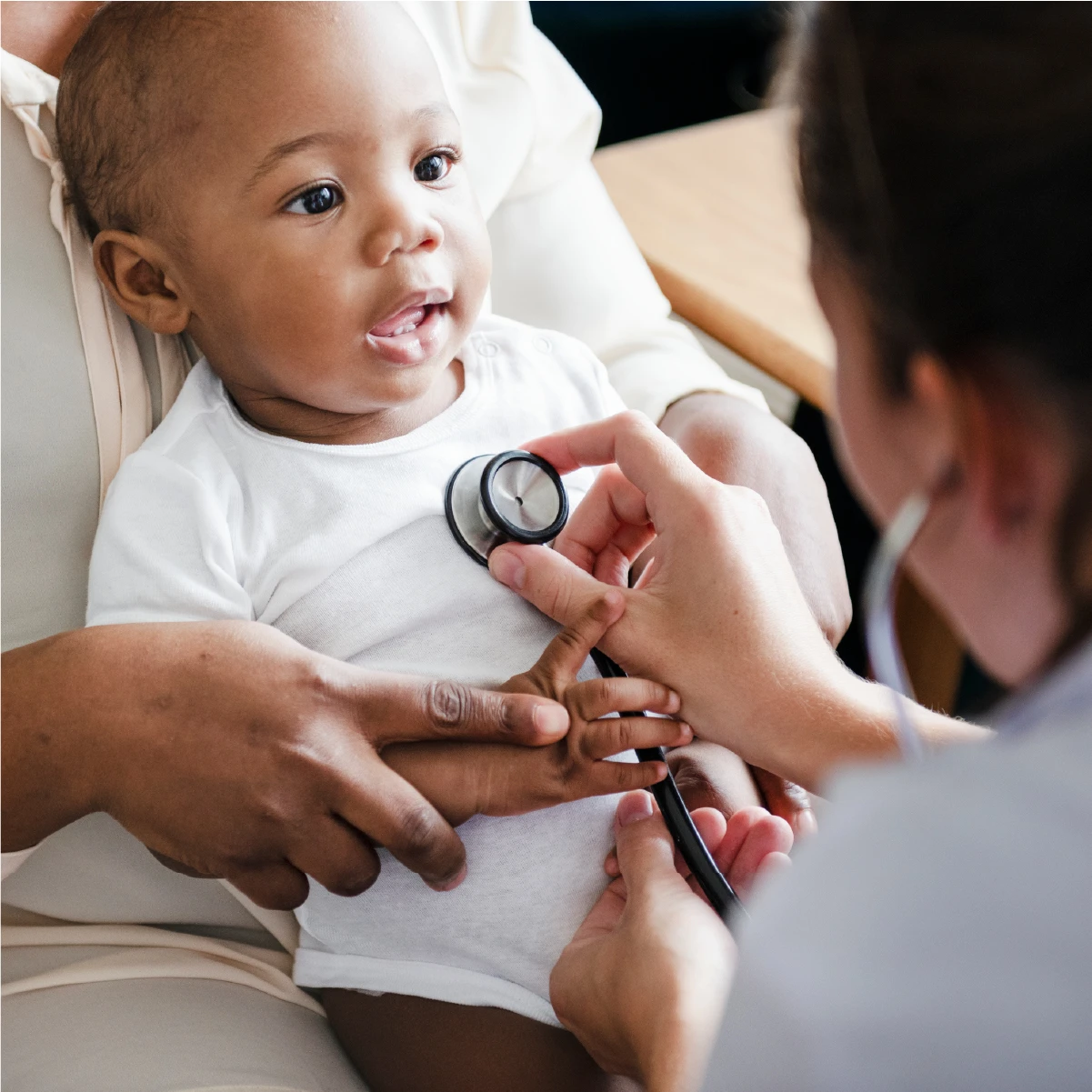 Health professional using a stethoscope to listen to an Infants chest