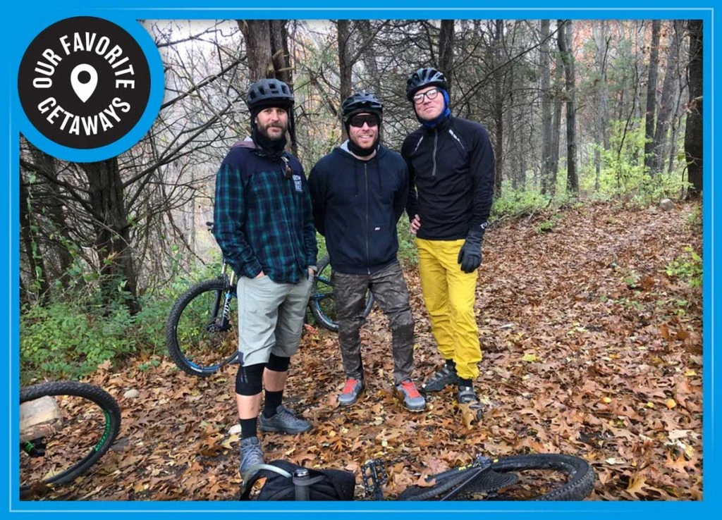 Group photo in the cold fall weather with mountain bikes on the ground among the fall leaves