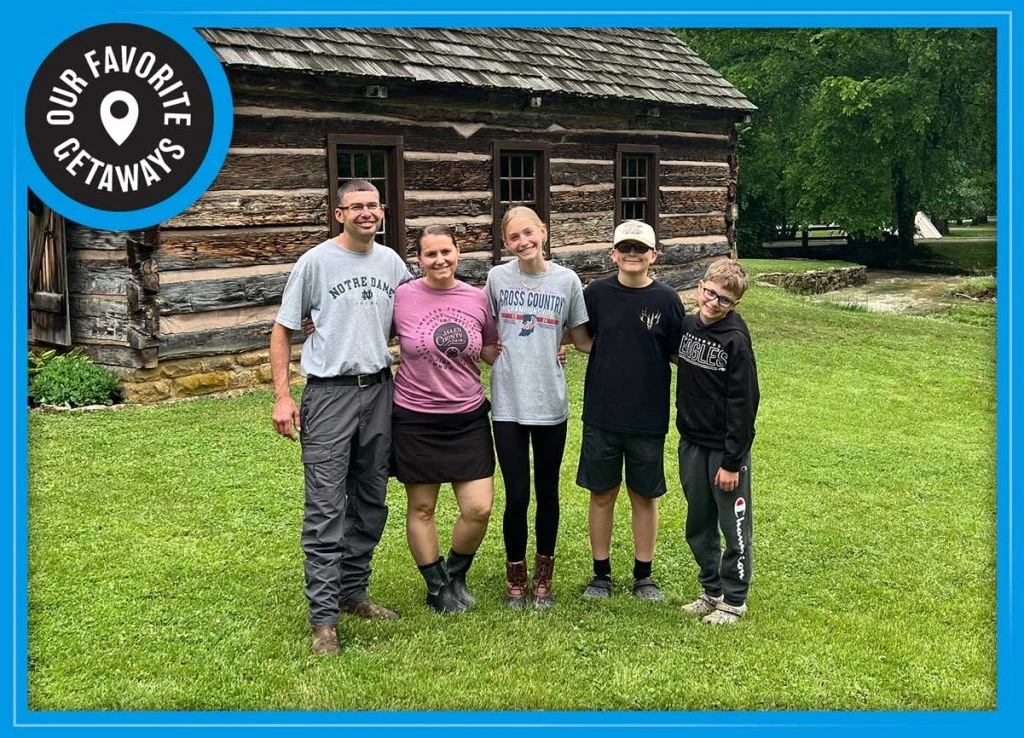 State Park family picture with a log cabin in the background