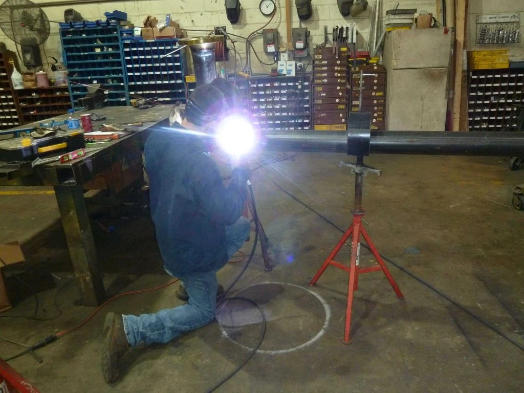 Pipe welding technician performing on-site welds during field installation project