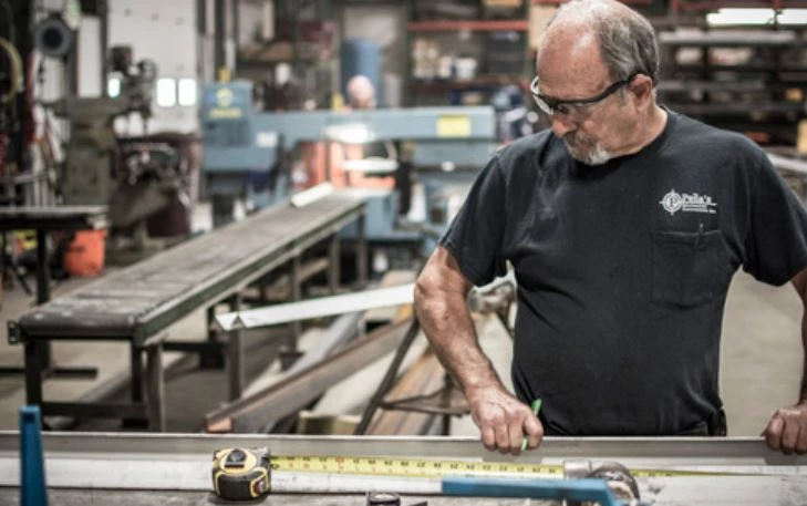 Experienced maintenance technician fabricating custom steel components at Peña Mechanical