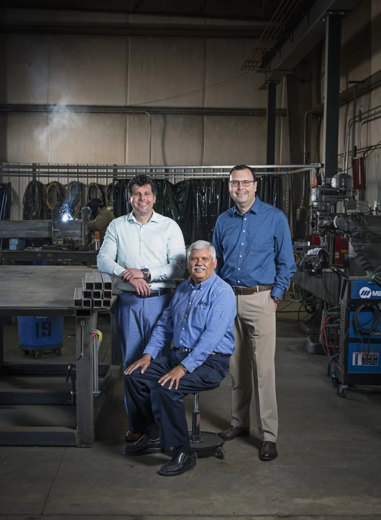 Founders of Peña Mechanical posing in their welding shop - Isaac Pena, Adam Pena, and their father Gil Pena