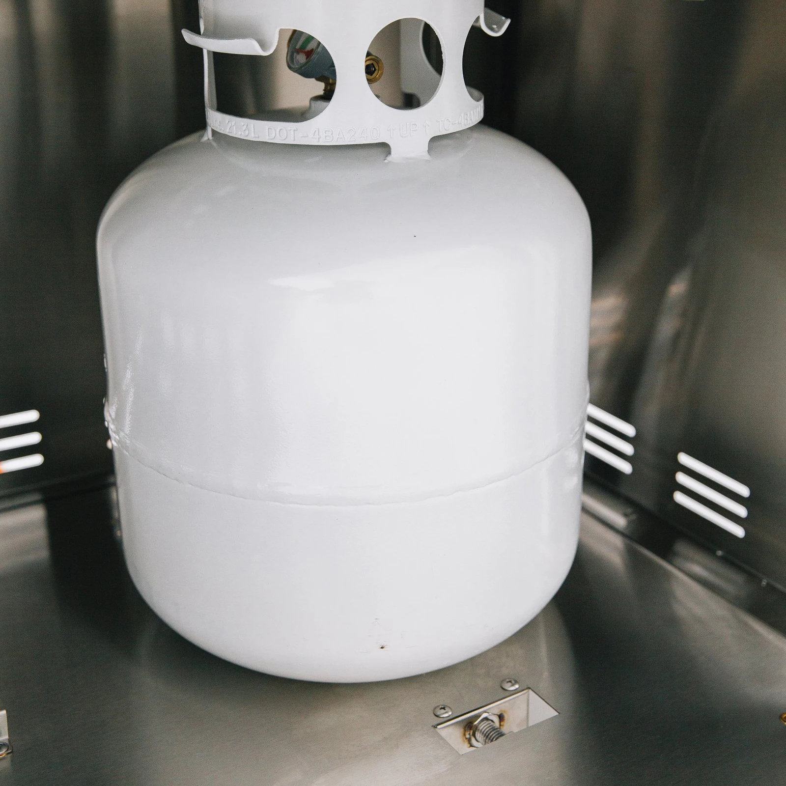 Propane tank secured inside the stainless steel storage compartment of a Summerset grill cart with double access doors