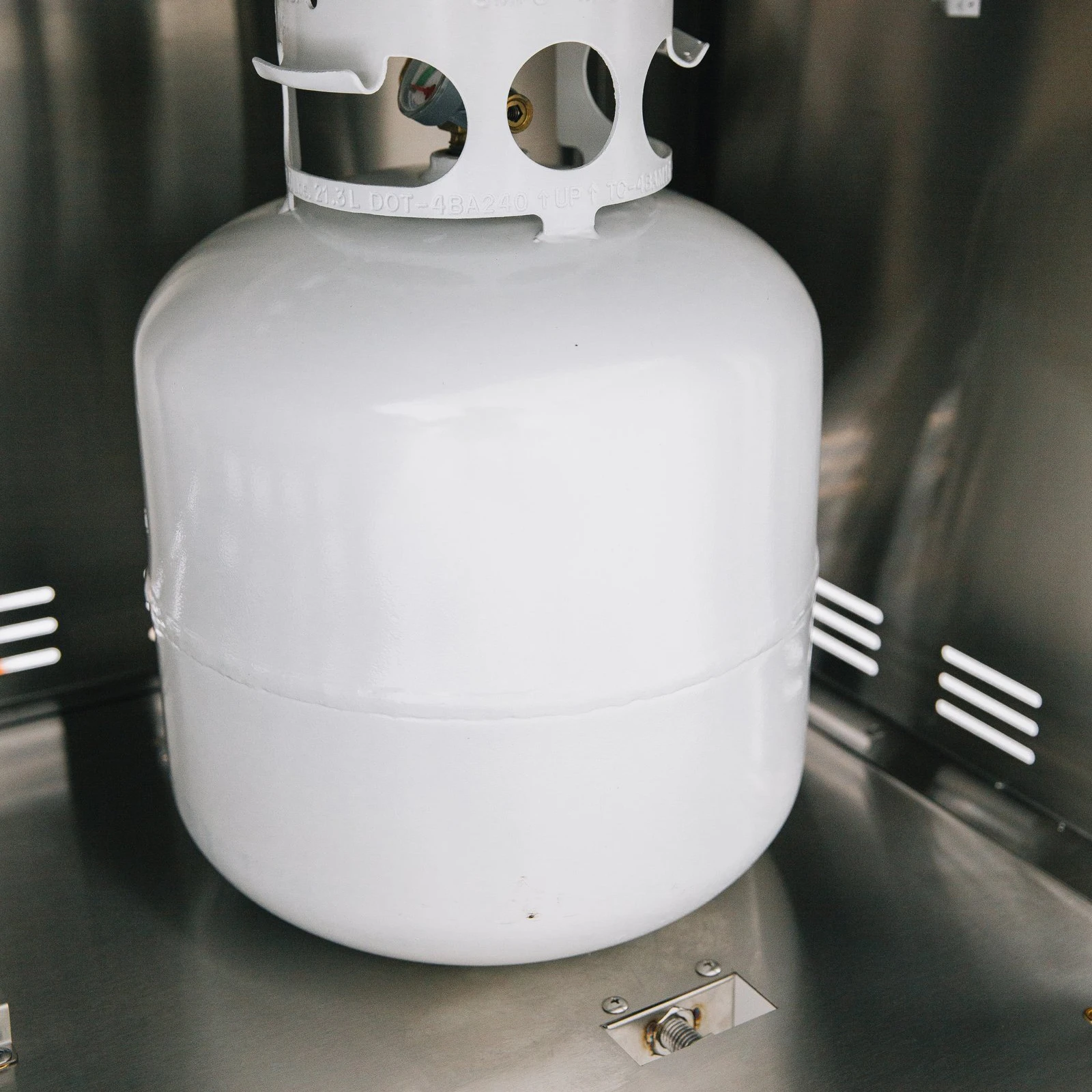 Propane tank secured inside the stainless steel storage compartment of a Summerset grill cart with double access doors