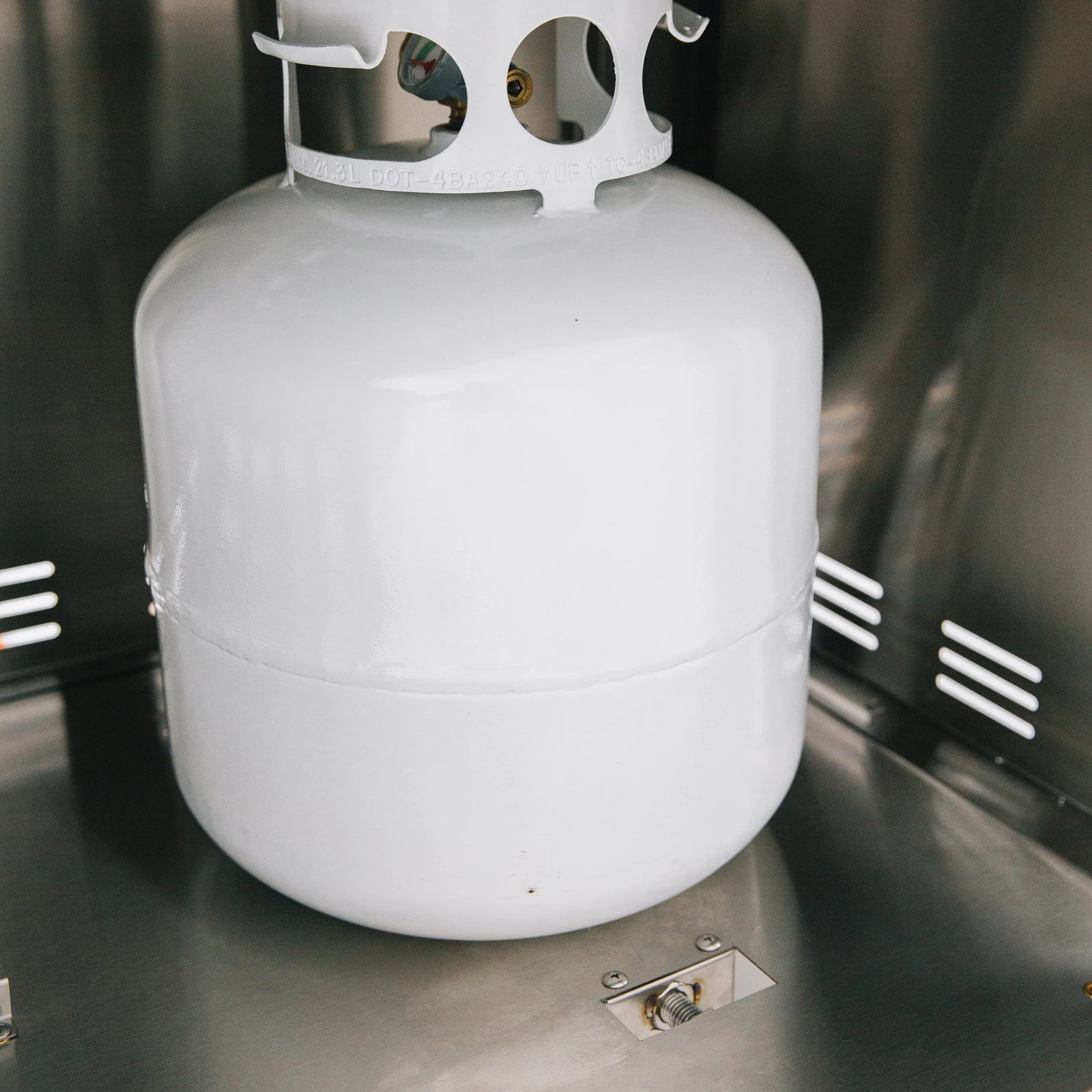 Propane tank secured inside the stainless steel storage compartment of a Summerset grill cart with double access doors