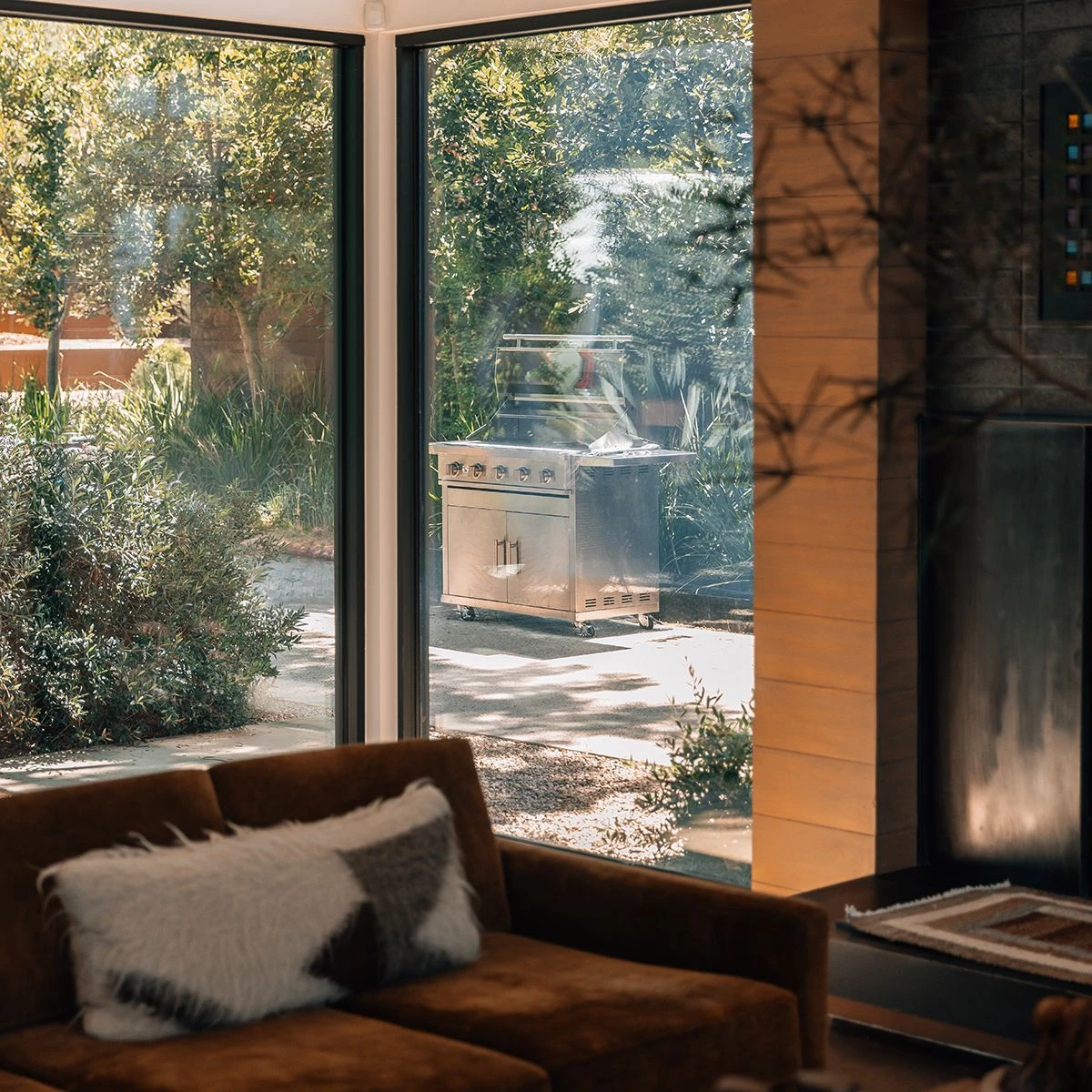 Summerset Sizzler 40-inch freestanding gas grill on its cart, seen through floor-to-ceiling windows from a living room