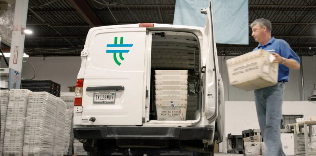 man putting box in delivery vehicle